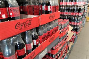 Hamburger Regierungskoalition will Abgabe auf zuckerhaltige Getränke Coca-Cola-Regal im Supermarkt, Symbol für Diskussion über Zuckerabgabe und Verbraucherhealth.