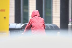 Wetterbericht für Sachsen-Anhalt (21.02.2026) Mann mit Kapuze steht im Regen, umgeben von grauem Himmel und herbstlicher Atmosphäre.