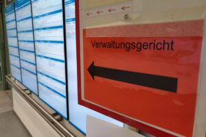 Immer mehr Flüchtlinge klagen gegen Asylbescheid Verwaltungsgericht zeigt Anstieg von Asylklagen, symbolisiert durch Gerichtssaal und Dokumente.