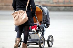 Warken begrüßt Nachbesserungen für Hebammen Mutter mit Kleinkind im Kinderwagen, symbolisiert Unterstützung und Wertschätzung für Geburtshilfe.